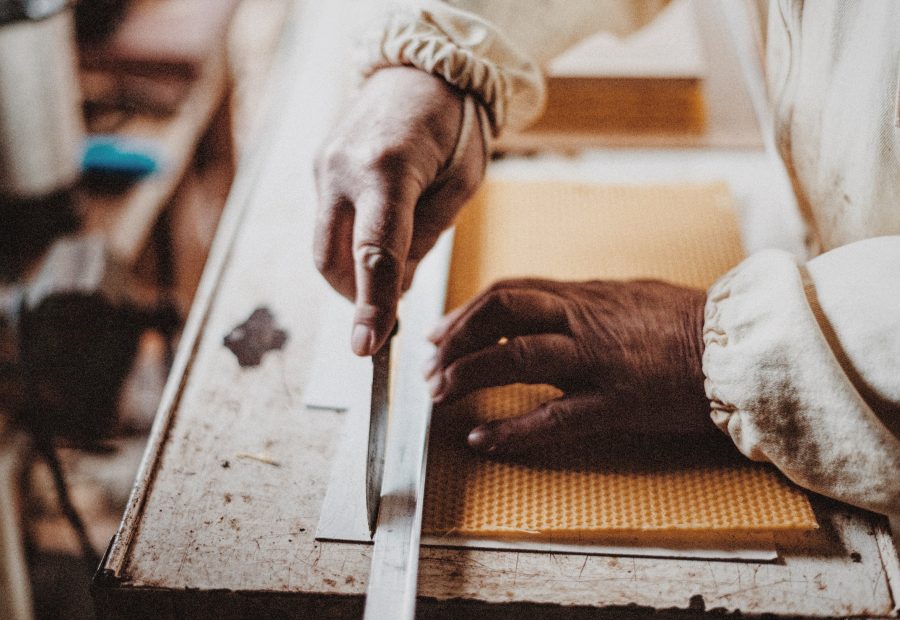 Hands marking a measurement against a steel rule
