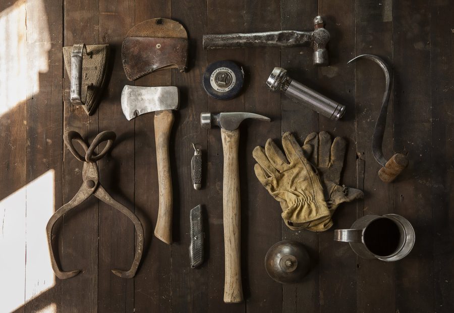 Hand tools laid out in rows on a dark bench
